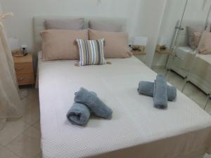 a bed with two blue stuffed animals on it at by The Sea Apartment in Iraklitsa