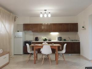 cocina con mesa de madera y electrodomésticos blancos en by The Sea Apartment, en Nea Iraklitsa