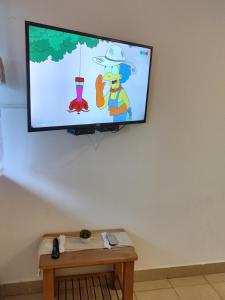 TV de pantalla plana en la pared con videojuego en Cerro Pirámide Alojamiento en Caviahue
