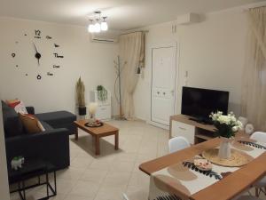 ein Wohnzimmer mit einem Sofa und einem Tisch in der Unterkunft by The Sea Apartment in Nea Iraklitsa