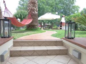 a hammock hanging from a tree in a park at by The Sea Apartment in Iraklitsa