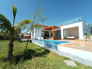 a villa with a swimming pool and a house at Casa VerdeMar Vichayito Perú in Vichayito