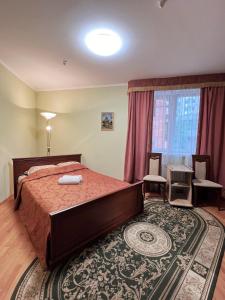 a bedroom with a bed and a table and a window at Hotel Premyer in Truskavets