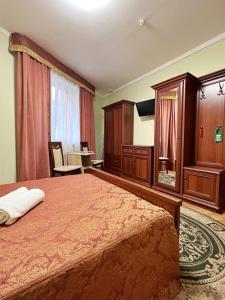 a bedroom with a large bed with a red bedspread at Hotel Premyer in Truskavets