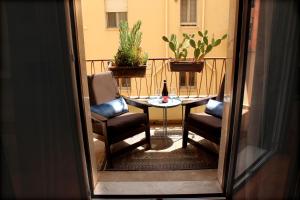 a balcony with a table and two chairs and a bottle of wine at Golden House - Trilocale nel Cuore di Agrigento in Agrigento +28 photos