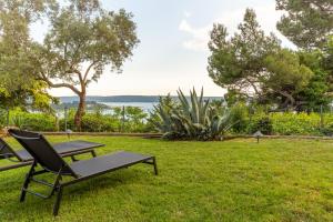 a picnic table and a bench in the grass at Villa Bellavista I in Portorož