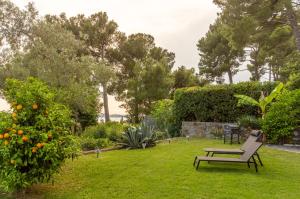 a garden with a bench in the grass at Villa Bellavista I in Portorož