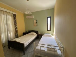sypialnia z dwoma łóżkami i oknem w obiekcie Villa Dalia w mieście Archangelos +33 zdjęcia