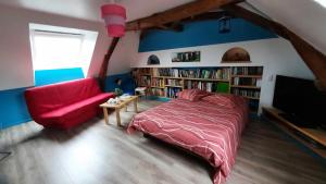 - une chambre avec un lit rouge et un canapé rouge dans l'établissement La Ménagerie, à Maigné