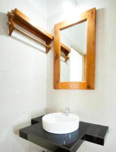 a bathroom with a sink and a mirror at eco trekking lodge Bar & tour's in Bukit Lawang