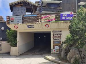 a building with signs in front of a garage at Le Cow'sy 1800 in Les Deux Alpes