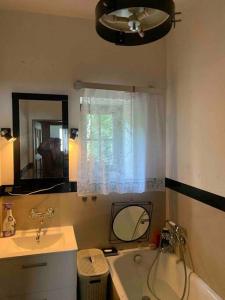 W łazience znajduje się wanna, umywalka i lustro. w obiekcie Apartament z naturą w Piasecznie w Piasecznie