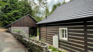 uma cabana de madeira com uma porta e uma janela em Chalupa Horní Heřmanice em Horní Heřmanice