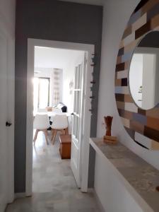 Un pasillo con espejo y un comedor. en Huétor Vega precioso apartamento, en Huétor Vega