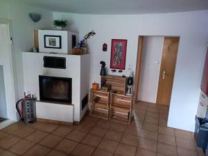 a living room with a tv and a fireplace at Historischer Hof, einladend für Mensch und Tier in Schenklengsfeld