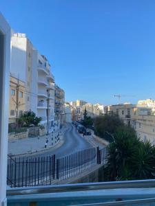 a view from a balcony of a street with buildings at San Giuliani Heights in St. Julianʼs