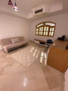 ein Wohnzimmer mit einem Bett, einem Tisch und einem Schreibtisch in der Unterkunft La Villa 91 in Monastir