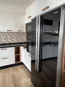 a kitchen with white cabinets and a stainless steel refrigerator at La Villa 91 in Monastir