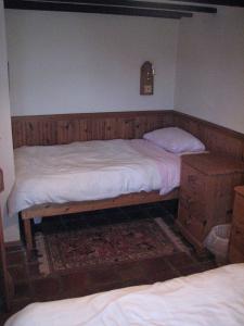 a bedroom with two twin beds and a dresser at Church Cottage in Bude