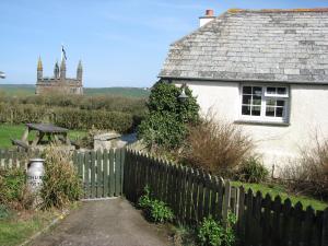 a white house with a fence in front of it at Church Cottage in Bude