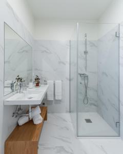 a white bathroom with a shower and a sink at Casa Amorim Girão in Fataunços