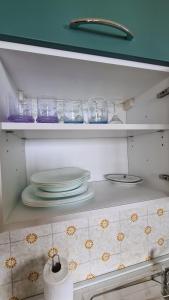una cocina con platos y vasos en un estante en Casa Luigi : Como Lake wonderful view, 