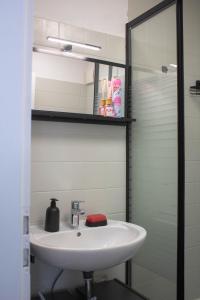 a bathroom with a white sink and a mirror at Modernes Studio mit großem Balkon, vollausgestatteter Küche und idealem Arbeitsplatz für Home Office in Gärtringen