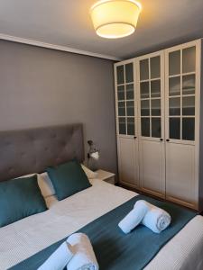 a bedroom with a bed with two towels on it at Paraíso Soleado: Piso con Terraza, Piscina y Garaje a 5 min de Playa in Castro-Urdiales