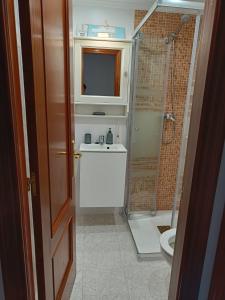a bathroom with a toilet and a sink and a shower at Paraíso Soleado: Piso con Terraza, Piscina y Garaje a 5 min de Playa in Castro-Urdiales