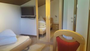 a small bedroom with a bed and a mirror at Oberangerhof in Lagundo