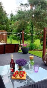 - une table avec une bouteille de vin et une planche à découper dans l'établissement Nad Potokiem, à Grąziowa