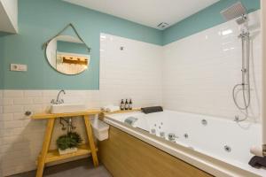 a bathroom with a tub and a sink and a mirror at DuermeCuenca in Cuenca +98 photos