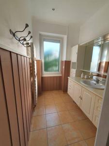 La salle de bains est pourvue d'un lavabo et d'une fenêtre. dans l'établissement Maison à 400 m du vieux port, à La Rochelle