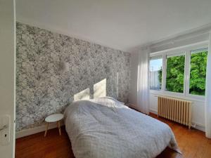 - une chambre avec un lit et un mur dans l'établissement Maison à 400 m du vieux port, à La Rochelle