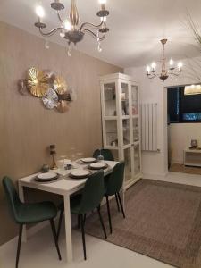 Herastau Apartment في بوخارست: غرفة طعام مع طاولة وكراسي خضراء