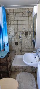 uma casa de banho com uma banheira e um lavatório em Ferienwohnung Gläser em Hilchenbach