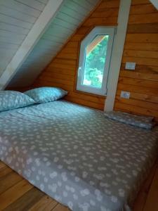 a bed in a room with a window at Tiny H in Ocnele Mari