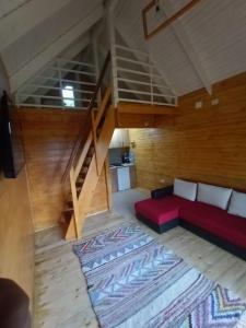 ein Wohnzimmer mit einem roten Sofa und einer Treppe in der Unterkunft Tiny H in Ocnele Mari