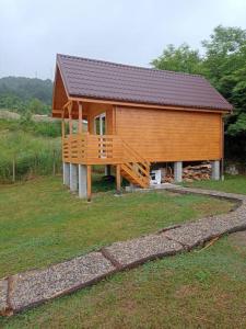 une grande maison en bois avec une grande terrasse dans l'établissement Tiny H, à Ocnele Mari