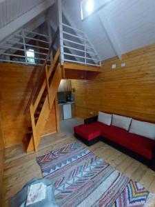 salon z czerwoną kanapą i schodami w obiekcie Tiny H w mieście Ocnele Mari