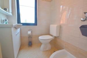 a bathroom with a toilet and a sink and a window at Panorama Punta in Umag +14 photos