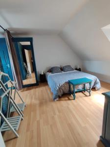 1 dormitorio con cama y mesa azul en Au Perchoir de la Chouette, en Verneuil-en-Halatte