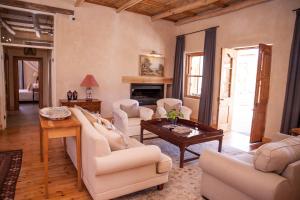 a living room with white furniture and a fireplace at Paradijs in Nieu-Bethesda in Nieu-Bethesda