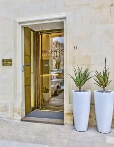 dos grandes ollas blancas sentadas frente a un edificio en Santacroce Luxury Rooms, en Lecce