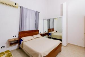 Hotel Villa Capri في بوكا شيكا: غرفة نوم بسريرين ومرآة