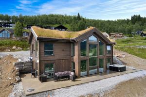 a tiny house with a grass roof on top at The Panorama Retreat - Rindabotn Cabin in Sogndal