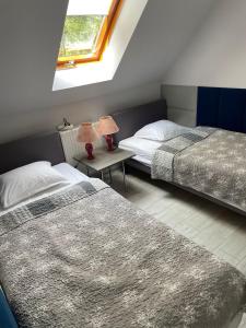 1 dormitorio con 2 camas y 1 mesa con 2 lámparas en Pensjonat Margo, en Karwieńskie Błoto Drugie