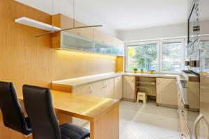 a kitchen with a wooden table and a desk at Family apartment with garden view in Bratislava