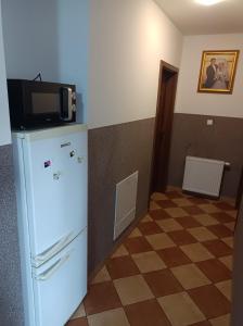 a kitchen with a microwave on top of a refrigerator at Kwatery Prywatne Majka in Władysławowo