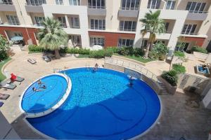 une grande piscine en face d'un bâtiment dans l'établissement 2 Bedroom Holiday Home Apartment with Pool View Brand New, à Dubaï